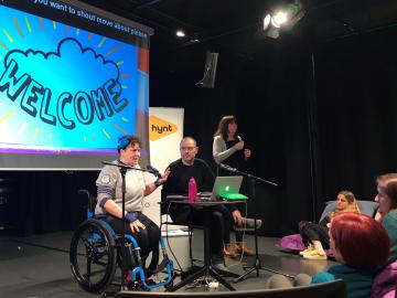 person in wheel chair presenting at a conference